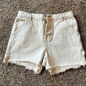 Size 28 Pacsun cut-off shorts with me on side of leg.